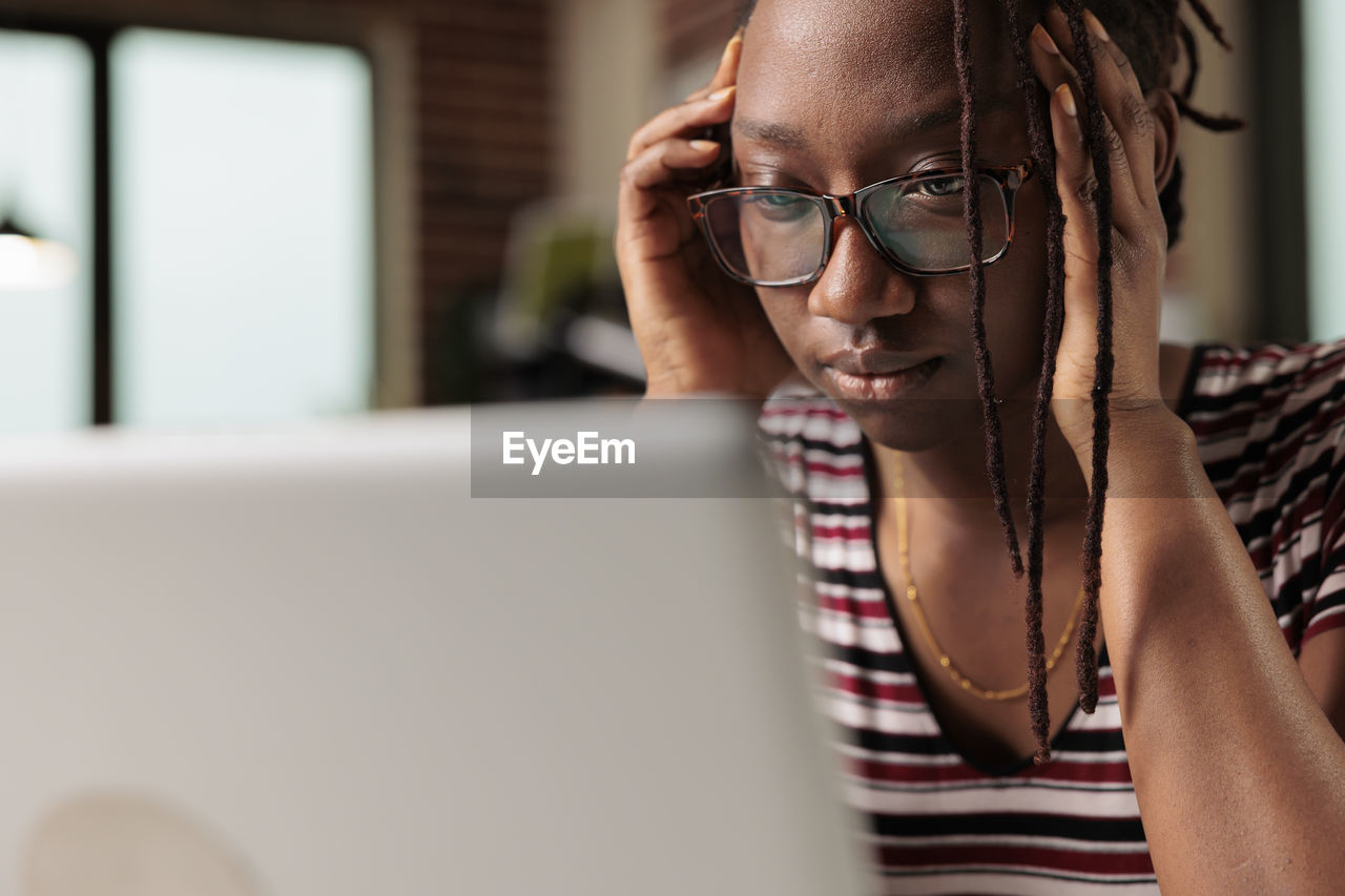 close-up of woman using laptop at home