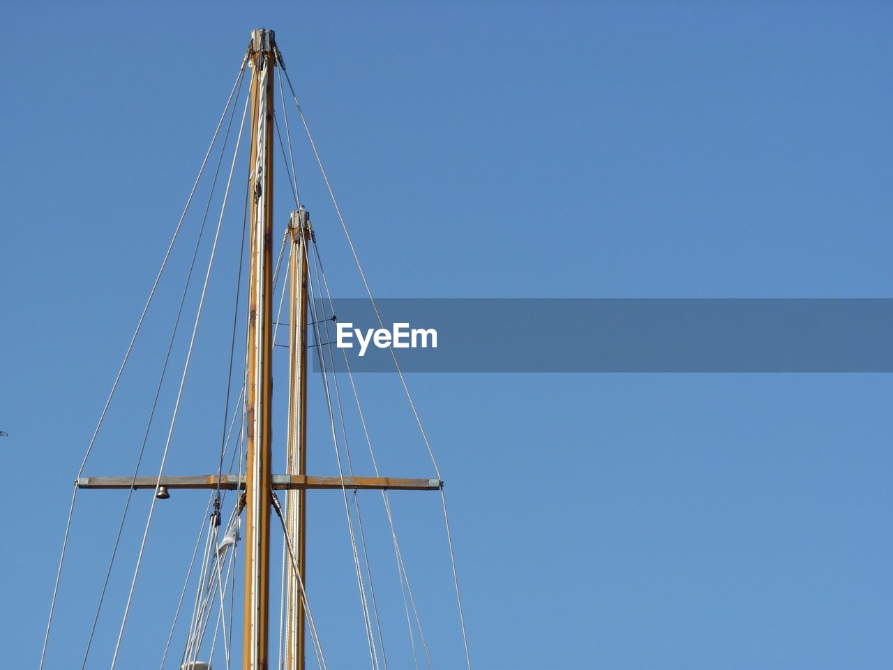 Low angle view of sailboat against clear blue sky