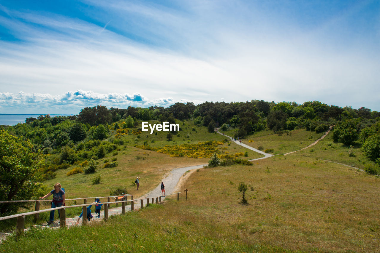 People walking on staircase amidst field