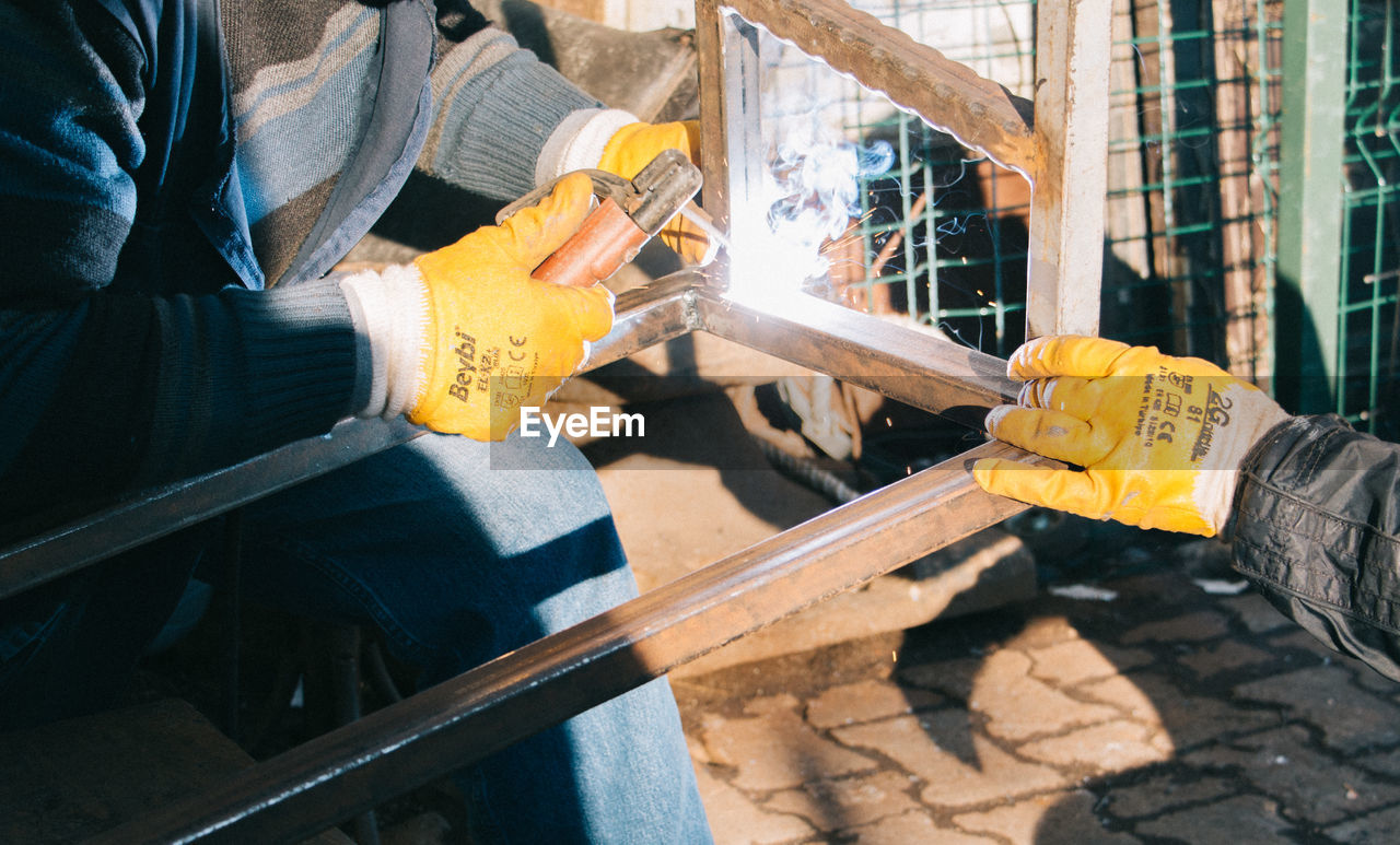 Cropped image of workers working at factory