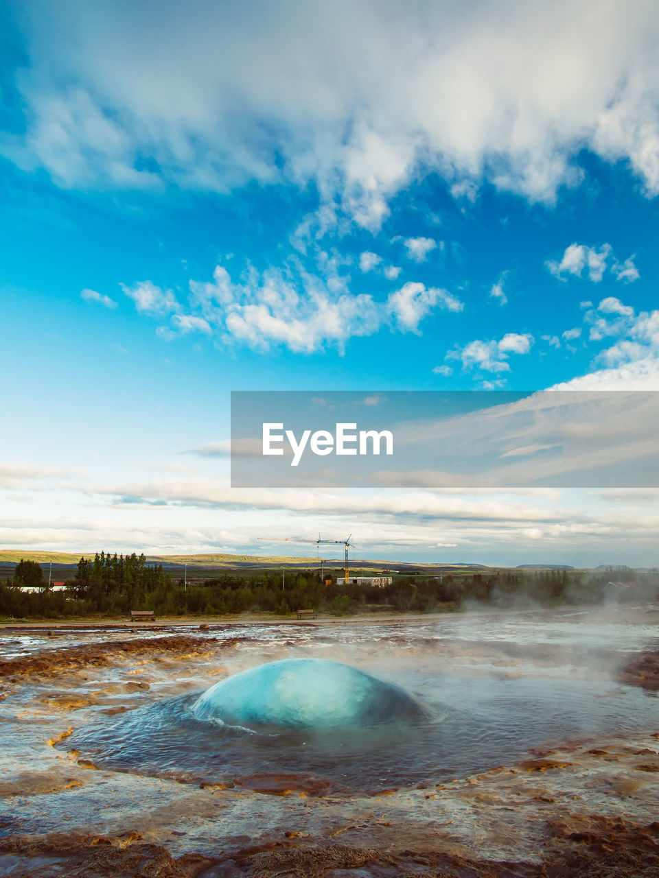 Geyser erupting against blue sky