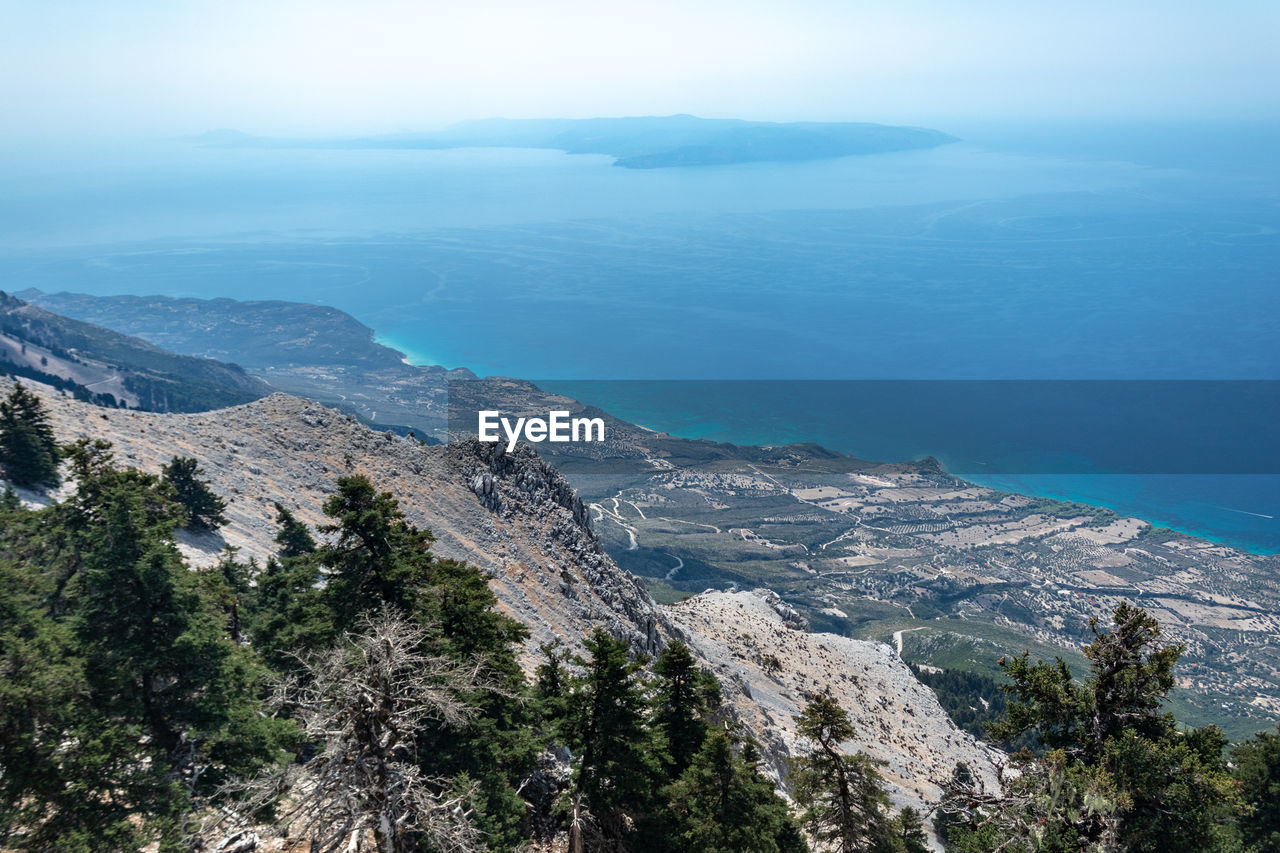 High angle view of sea and mountains against sky