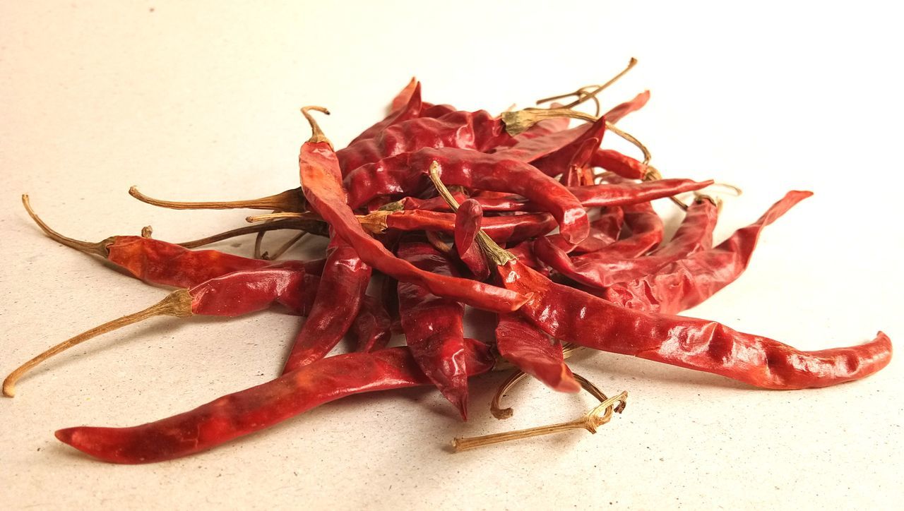 HIGH ANGLE VIEW OF RED CHILI PEPPERS ON WHITE BACKGROUND