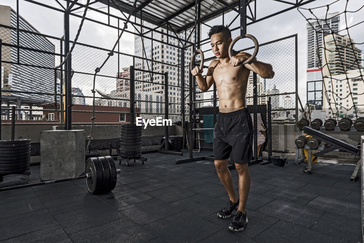 Man training at rooftop gym in bangkok