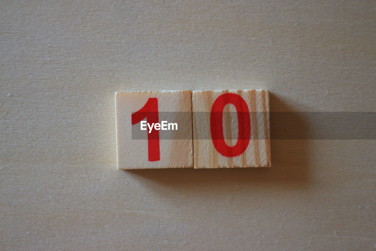 CLOSE-UP OF RED TEXT ON WOOD IN SHELF