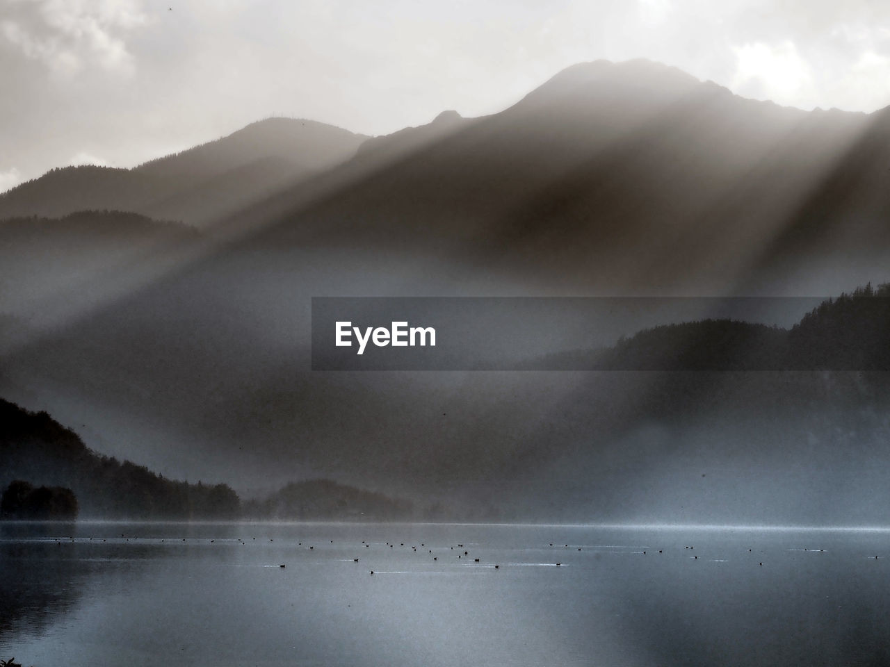 Scenic view of lake by mountains against sky