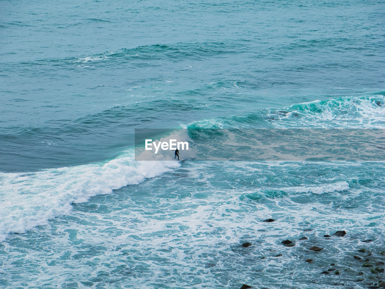 HIGH ANGLE VIEW OF MAN SWIMMING ON SEA