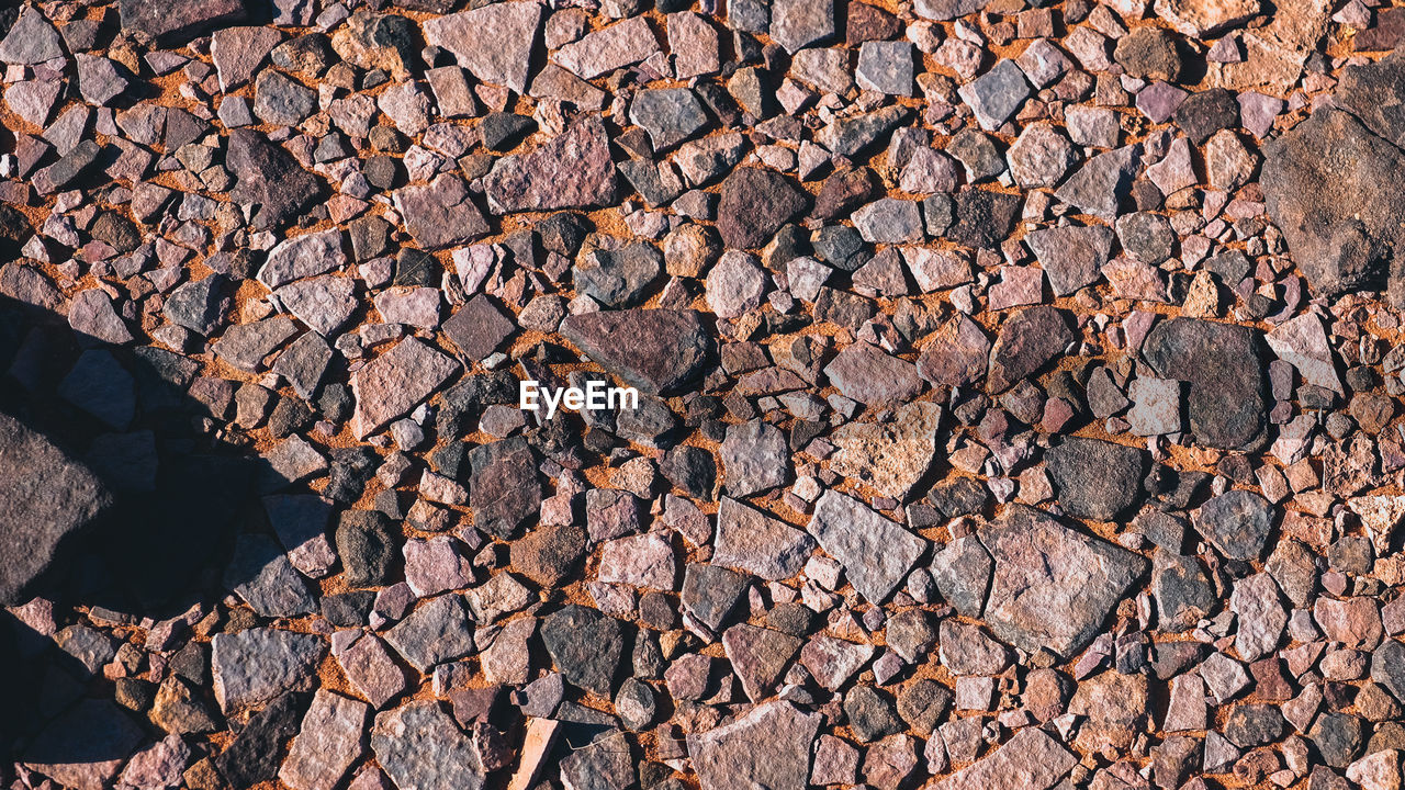 soil, wall, rock, backgrounds, full frame, nature, road surface, pattern, asphalt, day, no people, abundance, outdoors, textured, large group of objects, sunlight, wood, brick, high angle view, stone, land, brown, directly above, stone wall, rubble, architecture