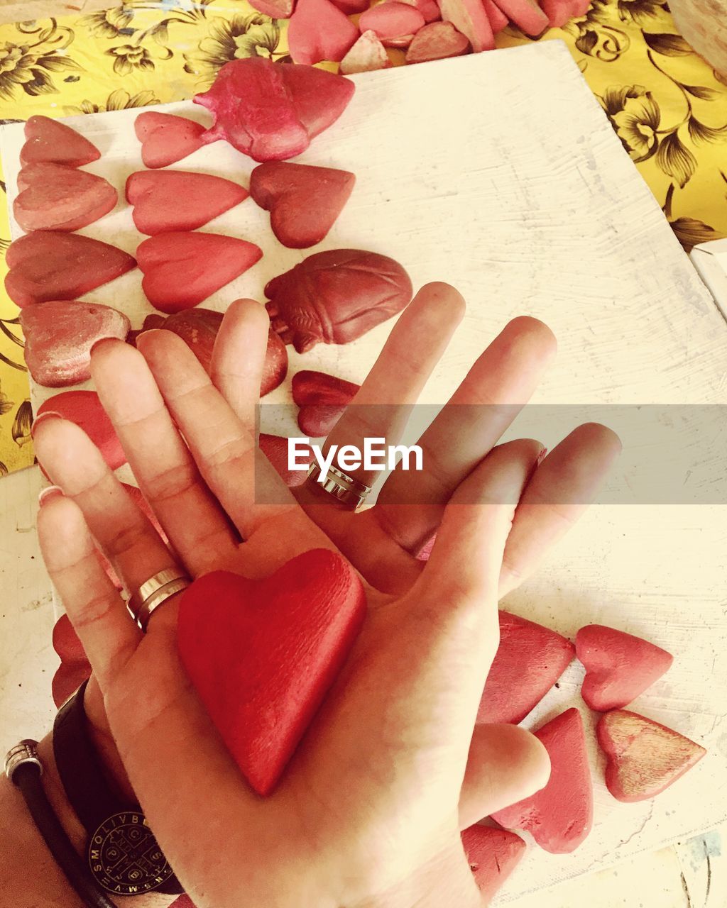 Close-up of couple holding red heart shapes