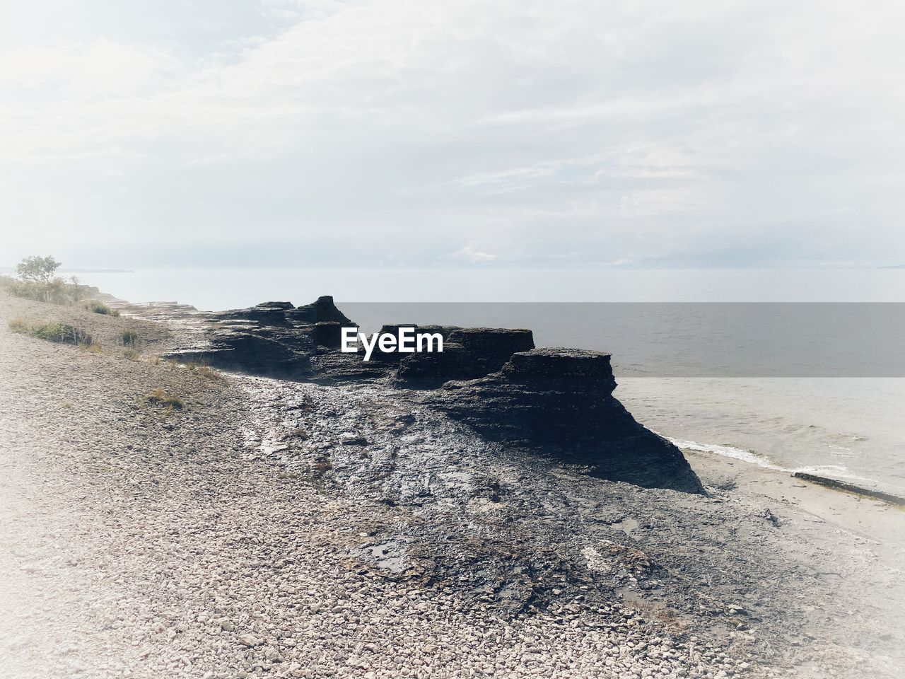 SCENIC VIEW OF ROCKY BEACH AGAINST SKY