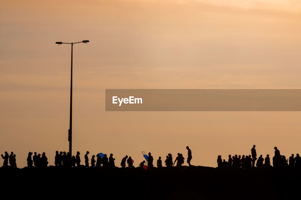 SILHOUETTE PEOPLE AGAINST SKY DURING SUNSET