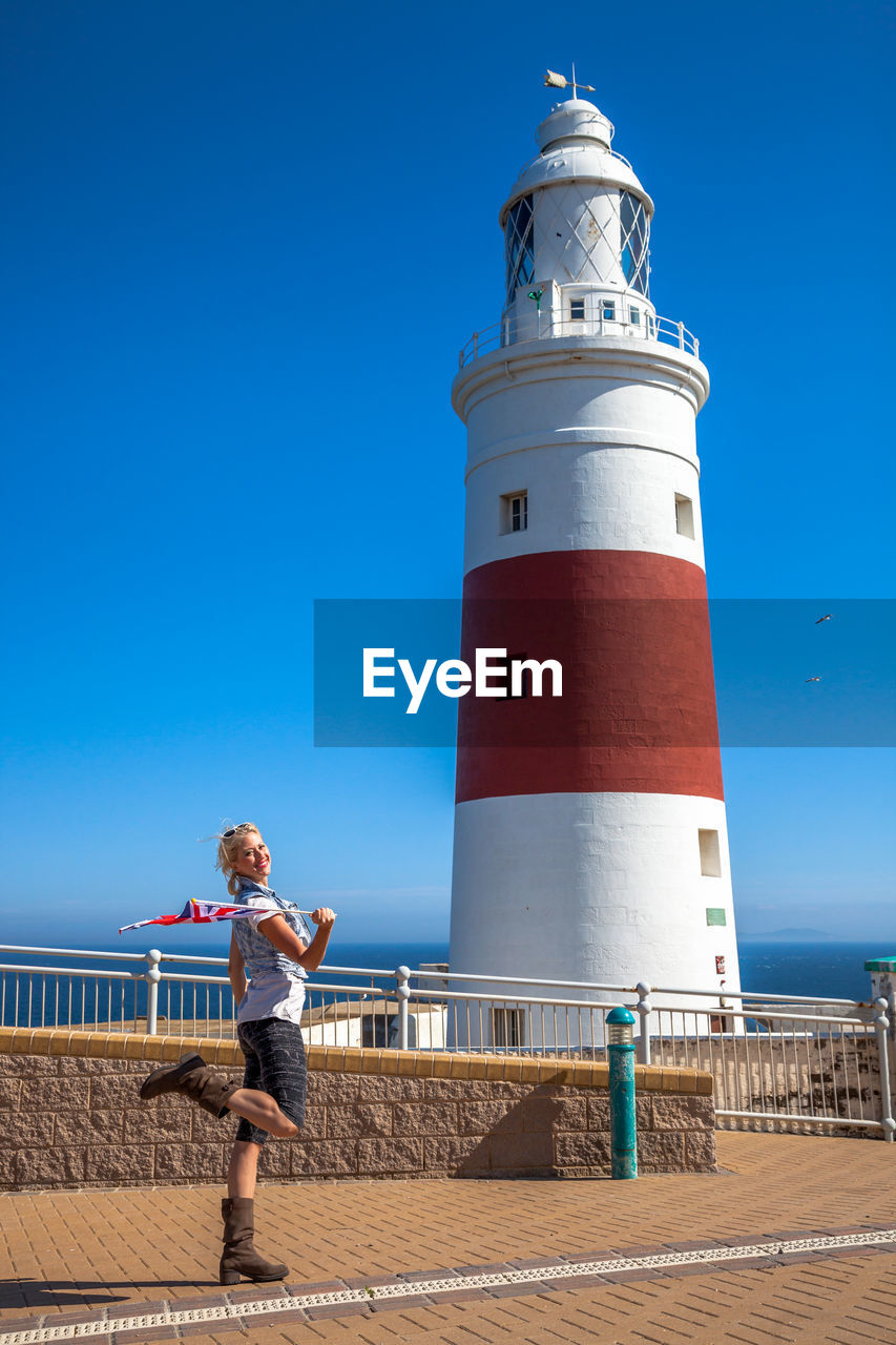 Woman standing against lighthouse