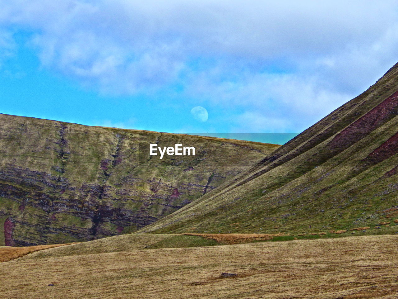 SCENIC VIEW OF MOUNTAINS AGAINST CLOUDY SKY