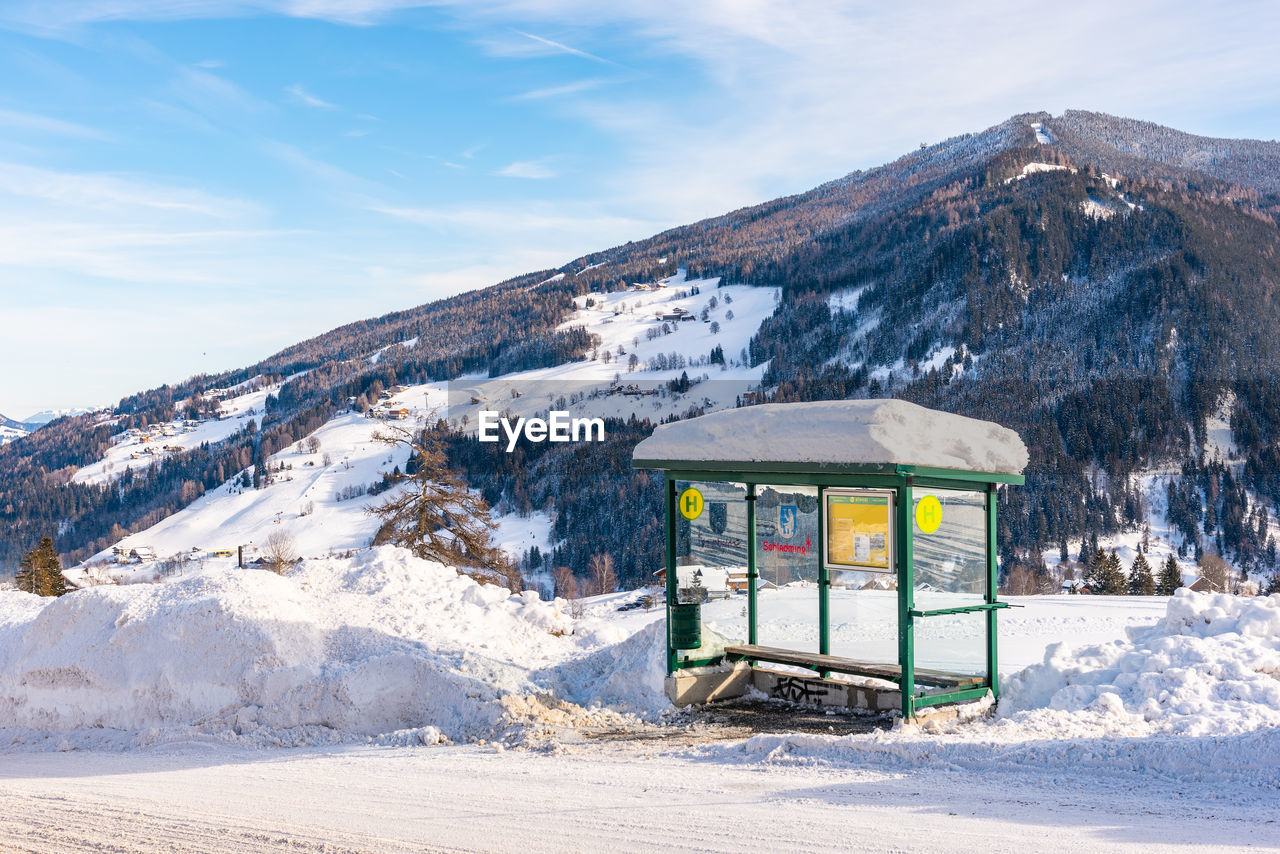 Ski bus stop at austria. scenic view of snowcapped mountains against sky. 