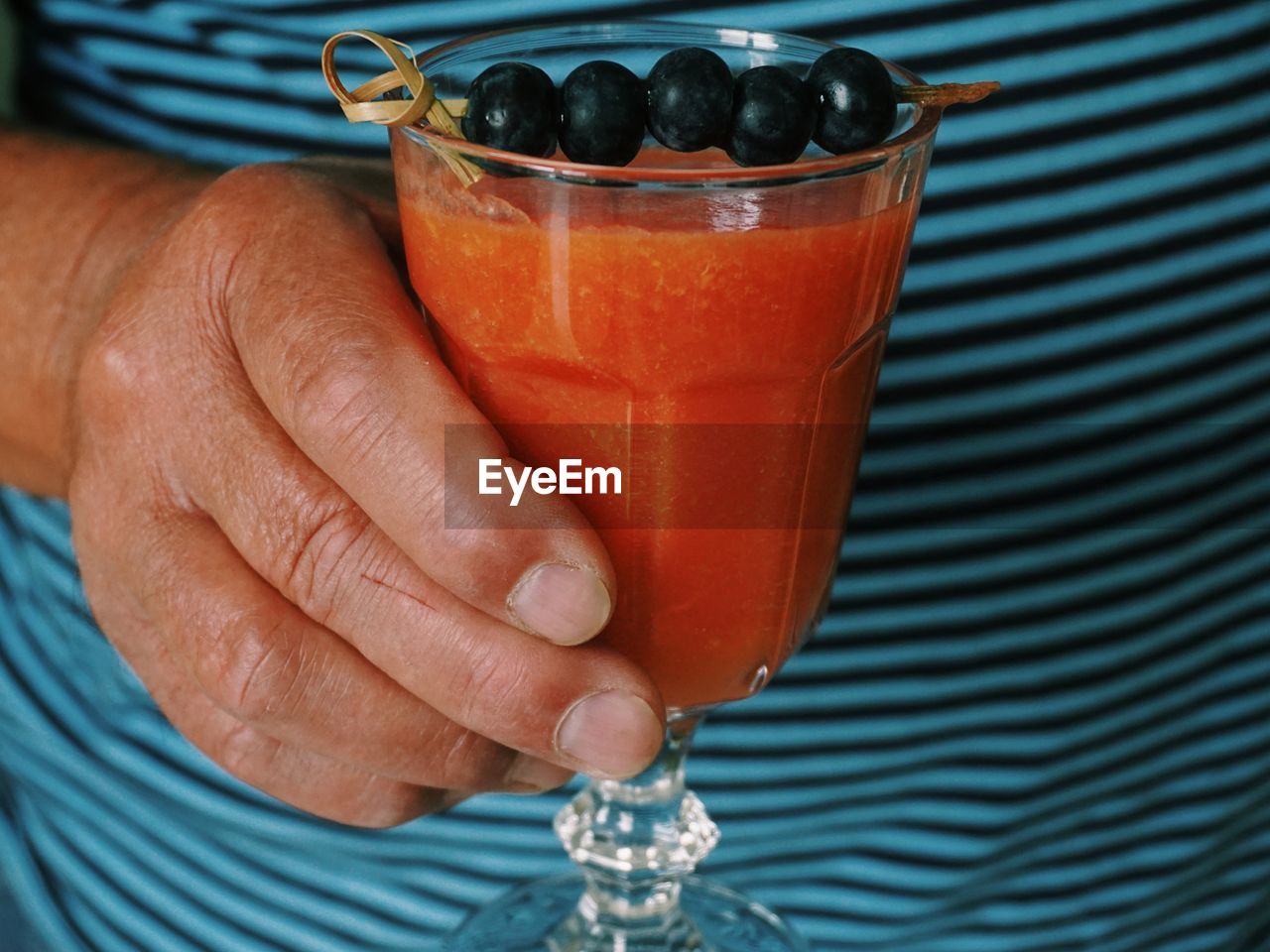 Close-up midsection of man holding juice