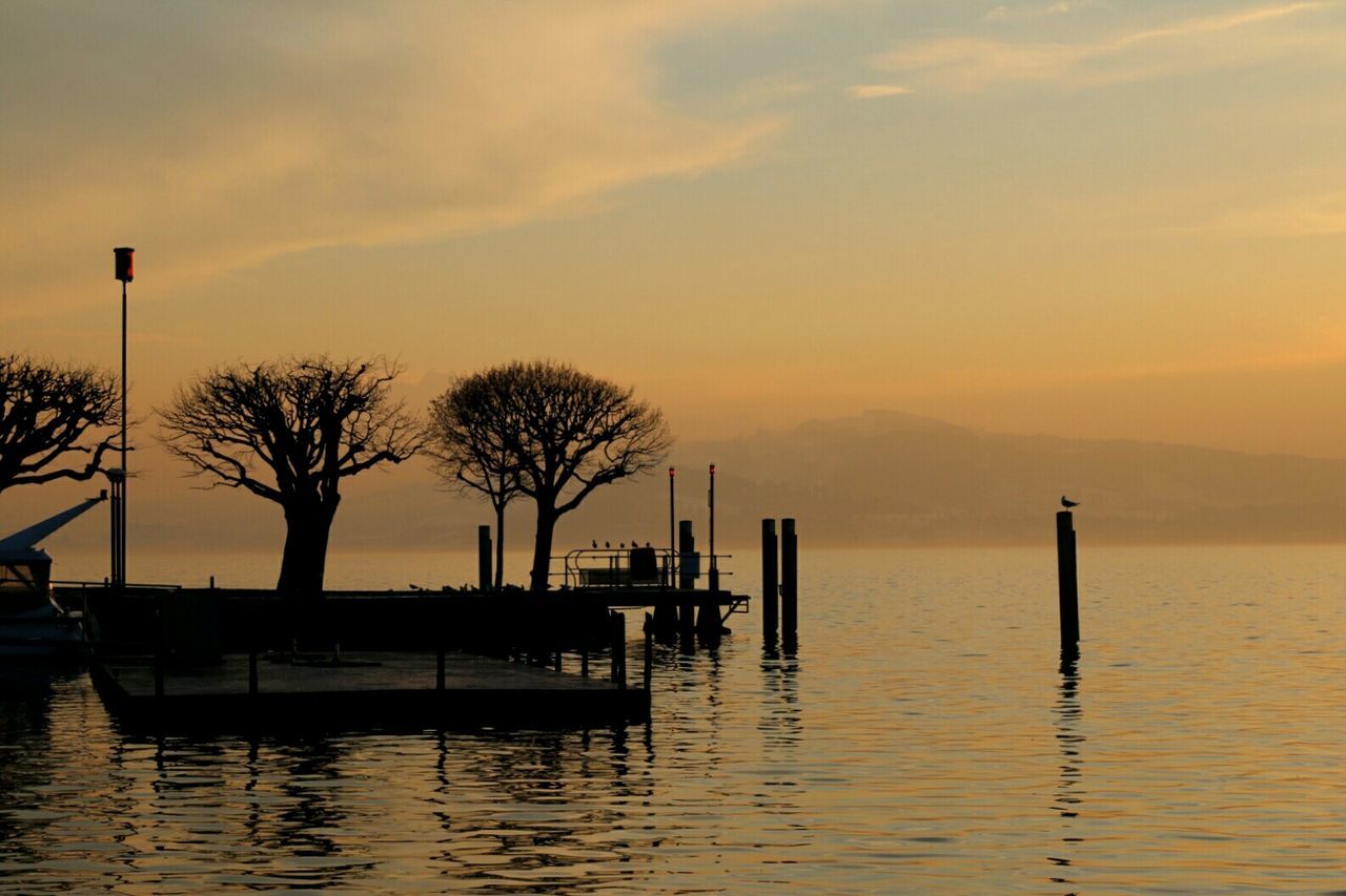 Silhouette of dock in lake