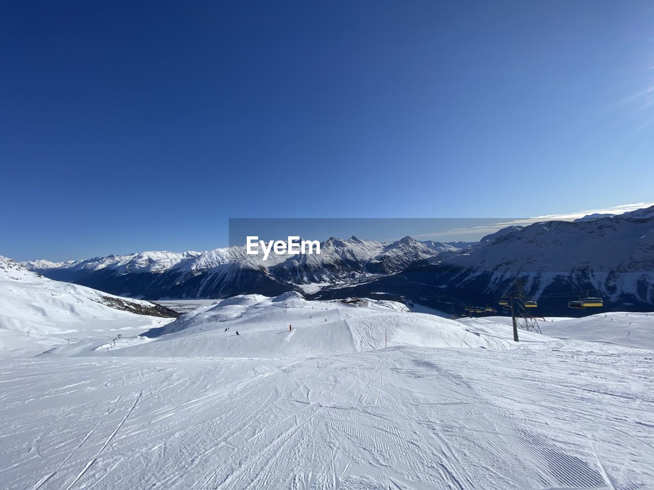 Scenic view of snowcapped mountains against clear blue sky