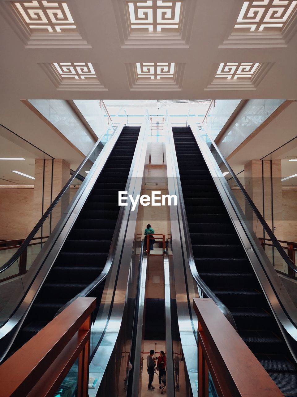 HIGH ANGLE VIEW OF PEOPLE ON ESCALATOR AT BUILDING