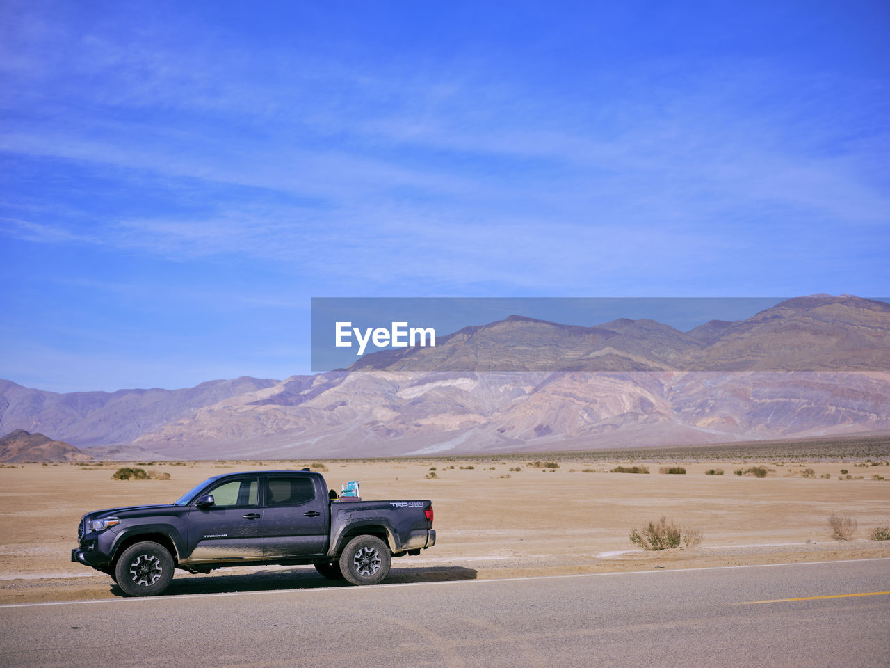 A toyota truck parked on the side of a desert highway, death valley