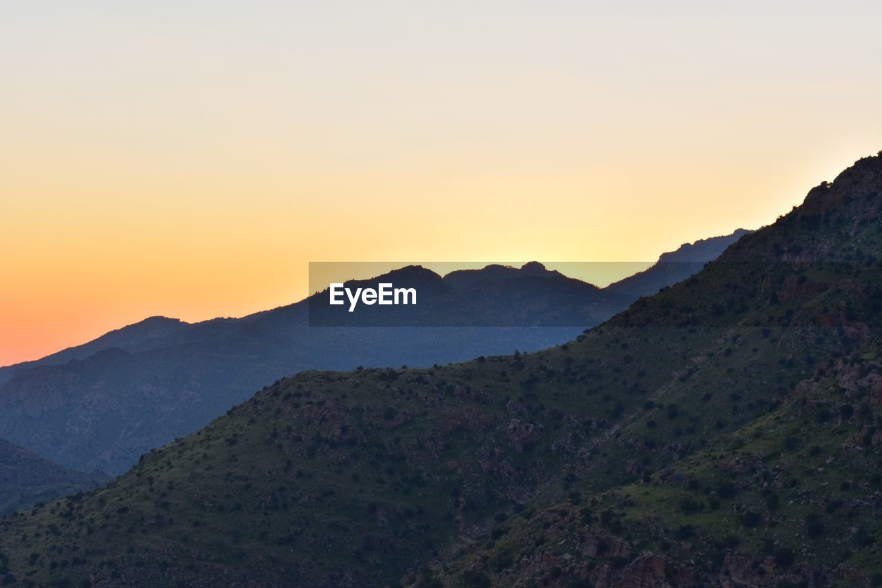 Scenic view of mountains against clear sky during sunset