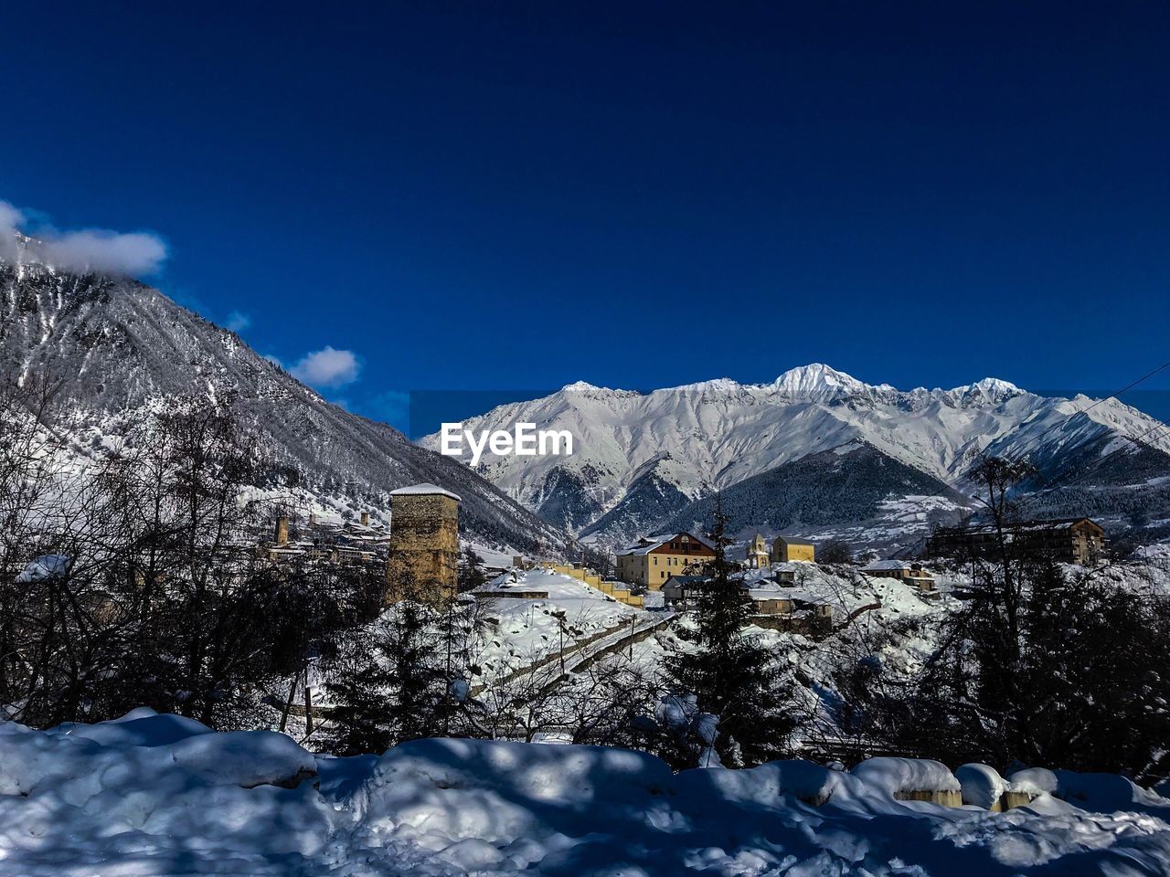 Scenic view of snowcapped mountains against blue sky