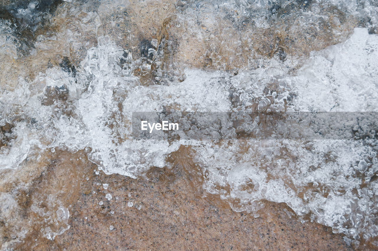 Directly above view of wave on shore at beach