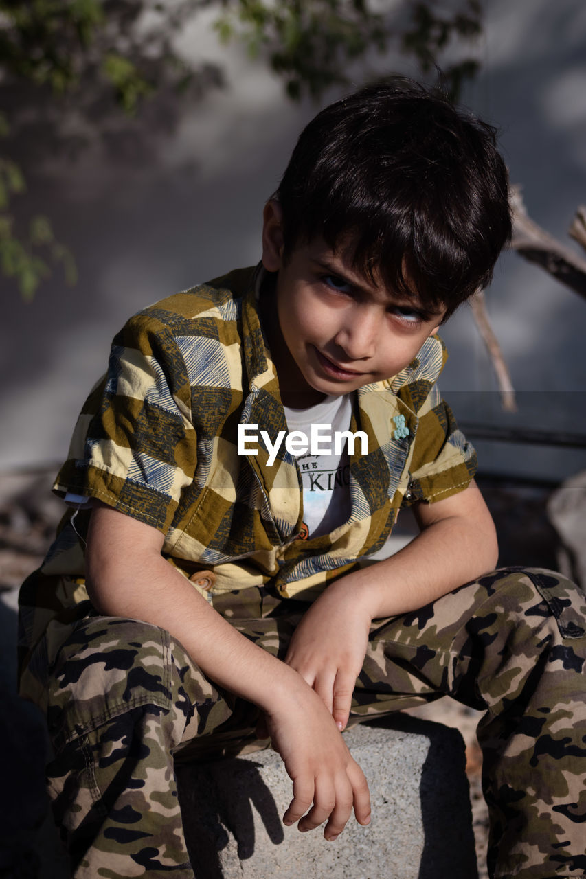 Portrait of boy sitting on bench