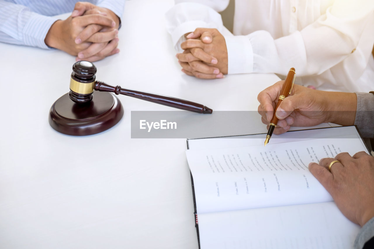 High angle view of couple sitting at desk with lawyer in court room