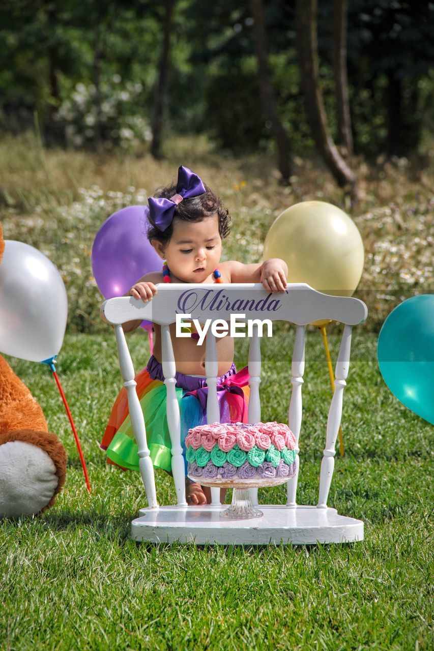 Cute girl with balloons on field