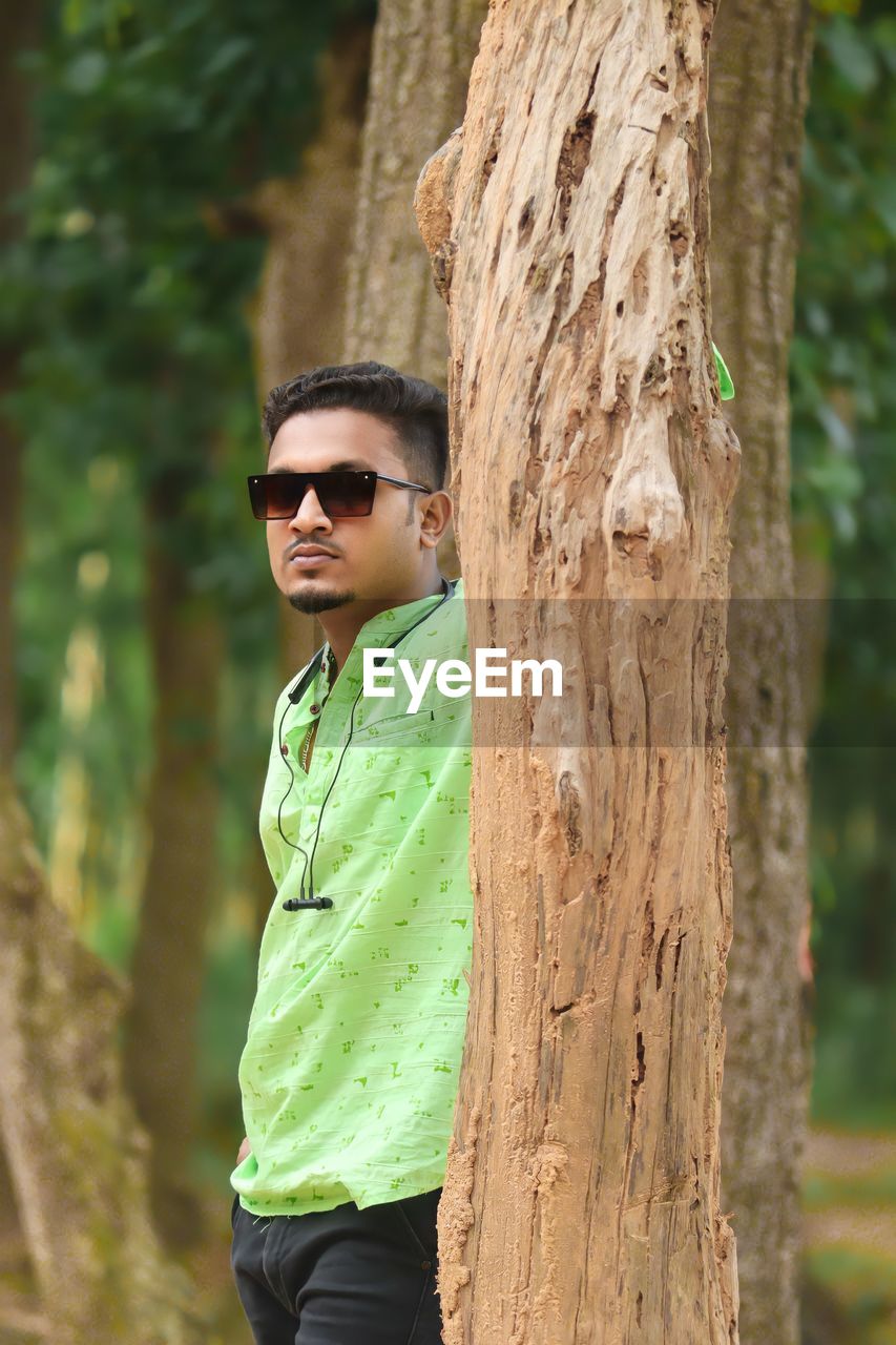 Portrait of young man standing in forest