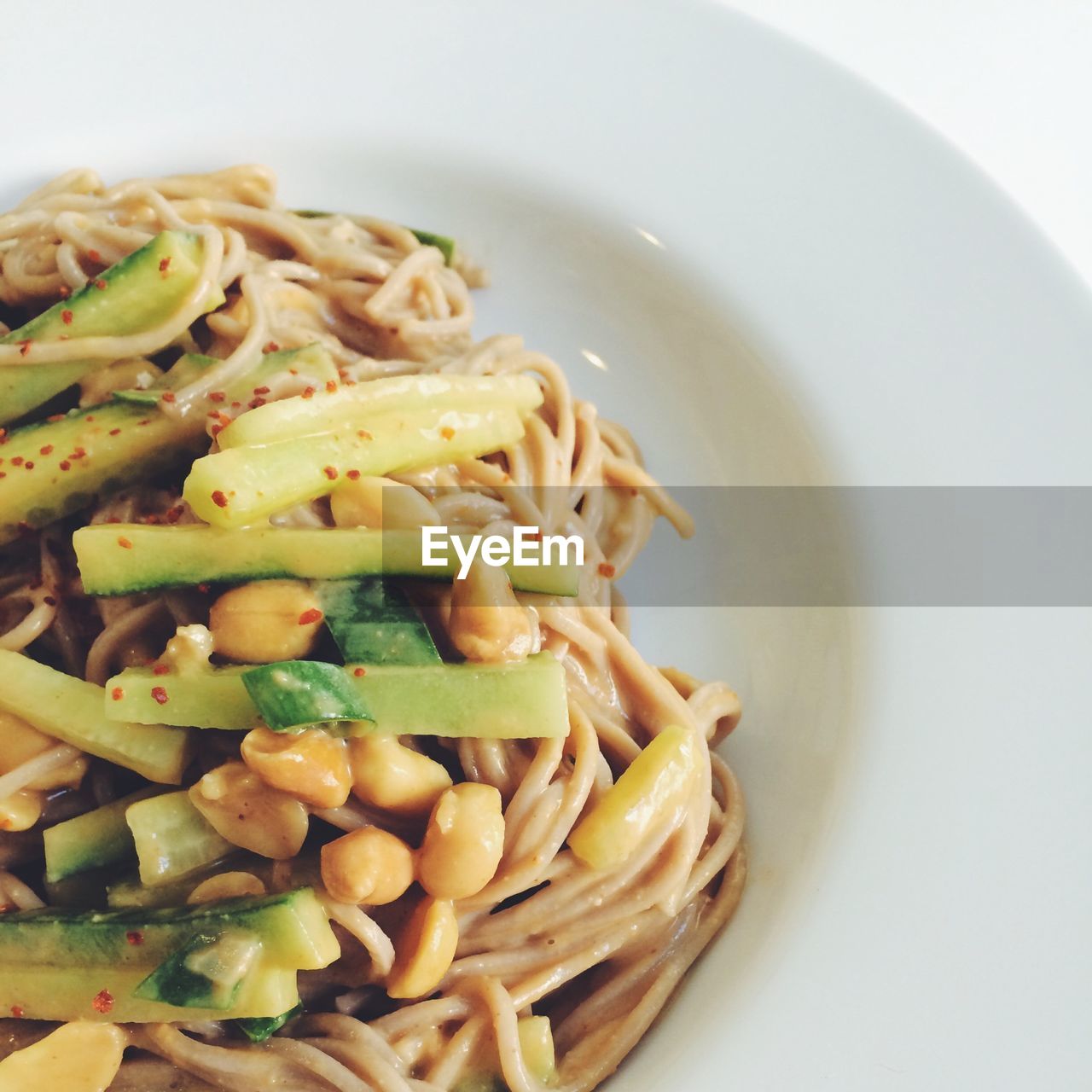 Pasta dish with vegetables on a white plate
