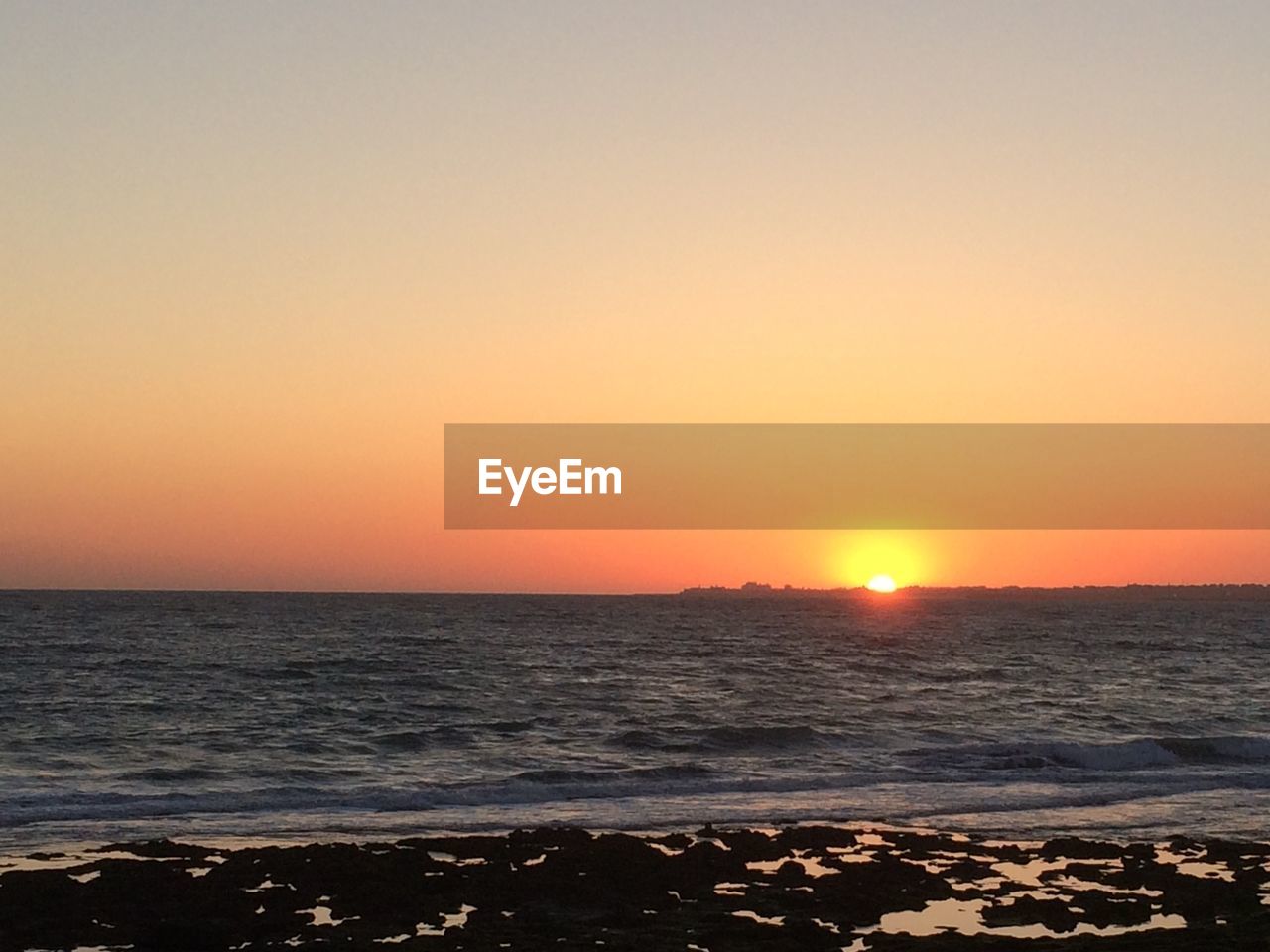 SCENIC VIEW OF SEA AGAINST ORANGE SKY