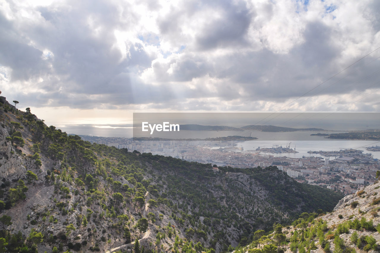 Scenic view of mountains and river against cloudy sky