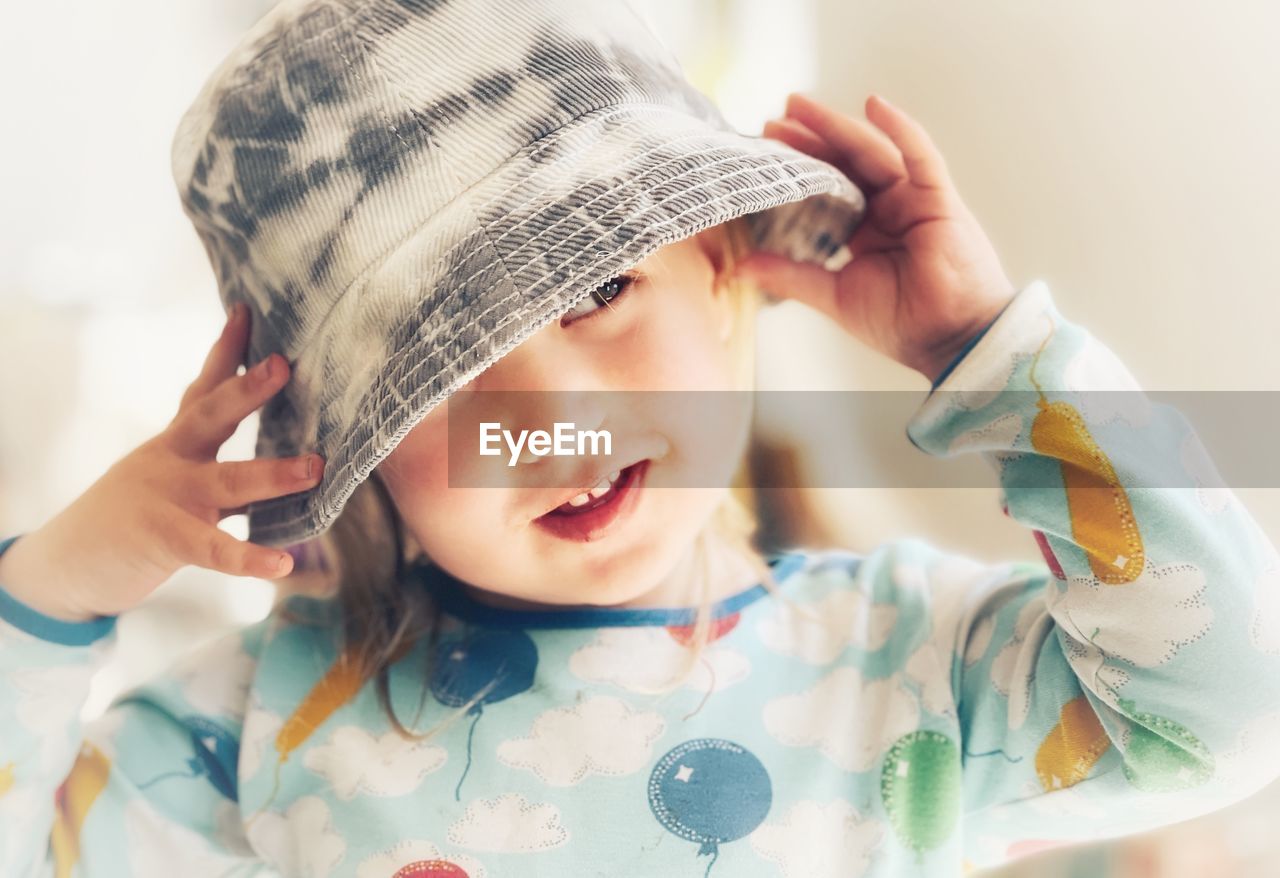 Cute girl wearing hat sitting at home