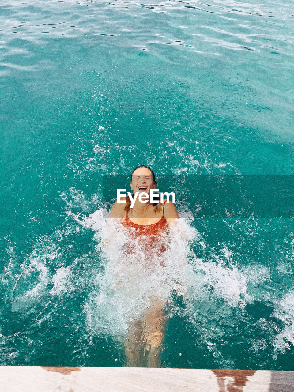 Portrait of smiling woman swimming in pool