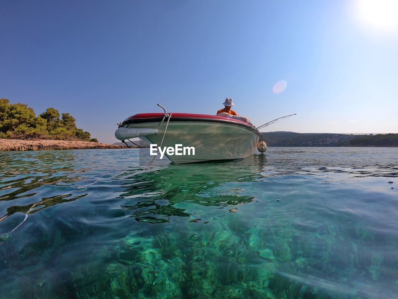 Portrait of senior man on a boat with clear sea and blue sky in background