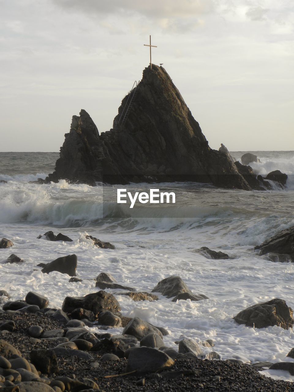 ROCK FORMATIONS ON SHORE AGAINST SKY