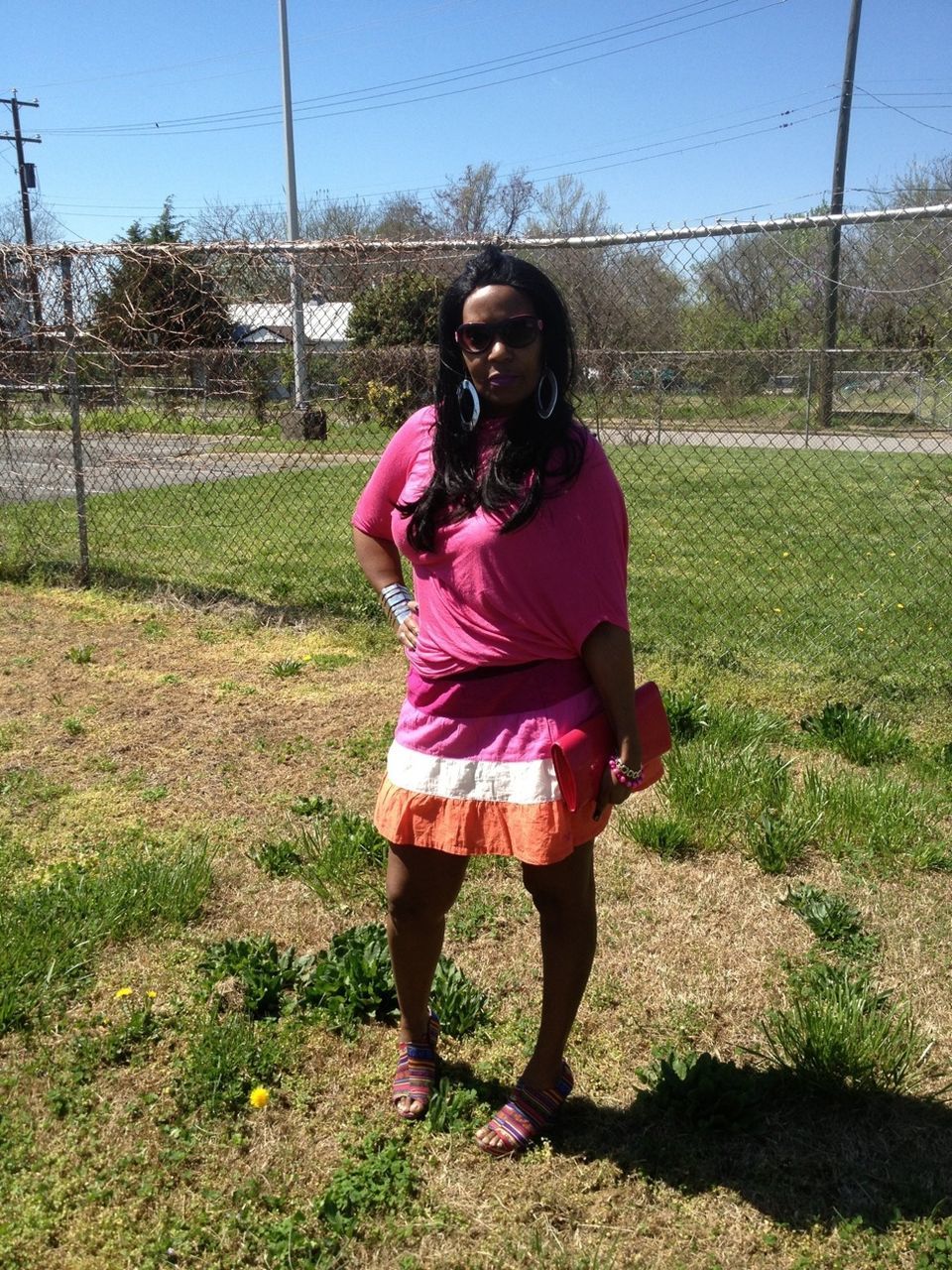 YOUNG WOMAN STANDING ON GRASSY FIELD