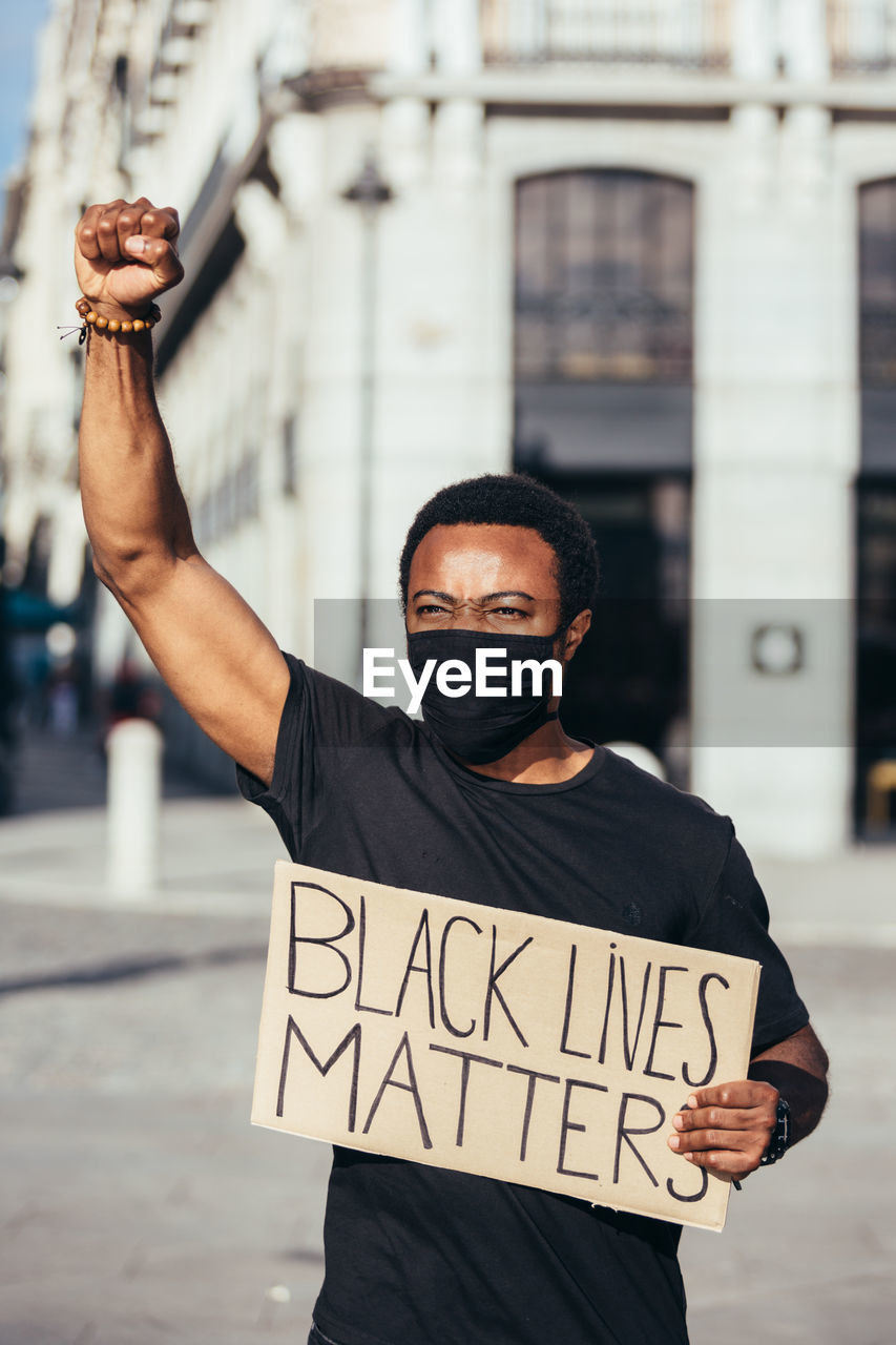 Man protesting at a rally for racial equality holding a poster against racism. black lives matter.