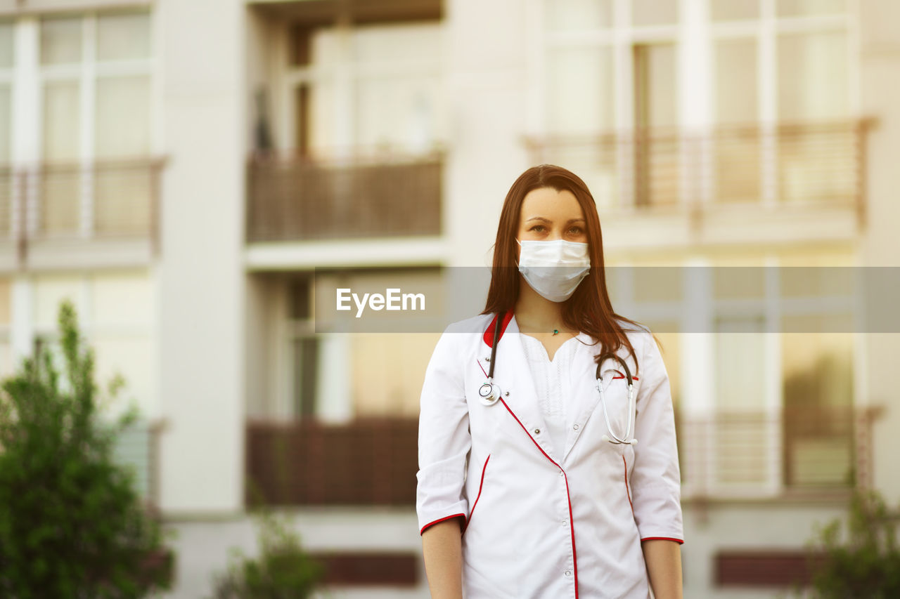 Portrait of doctor wearing mask standing outdoors