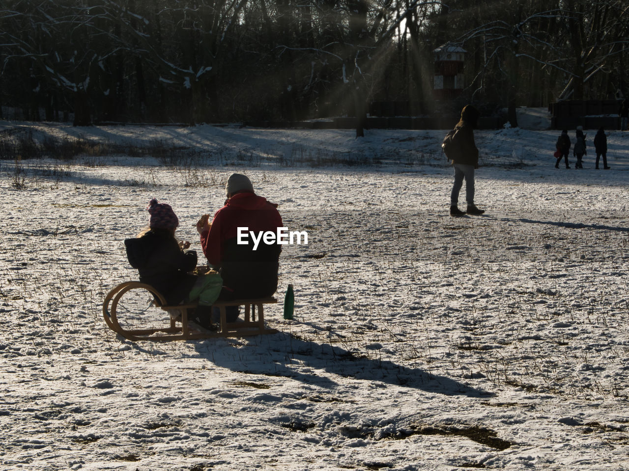 REAR VIEW OF PEOPLE RIDING MOTORCYCLE ON SNOW