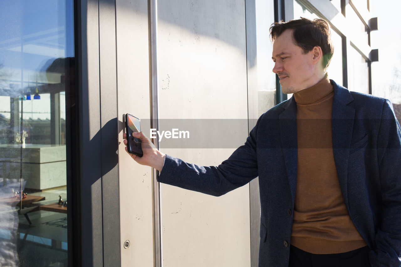 Businessman using mobile phone outdoors