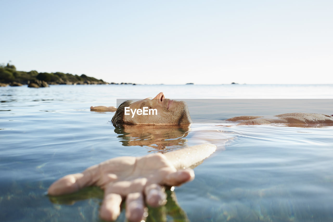 Relaxed mature man floating in the sea