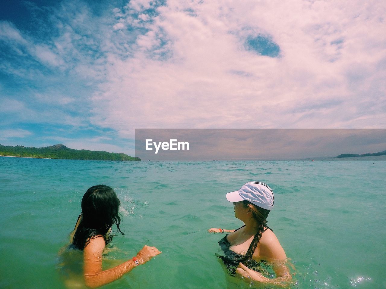 Women swimming in lake against sky during summer