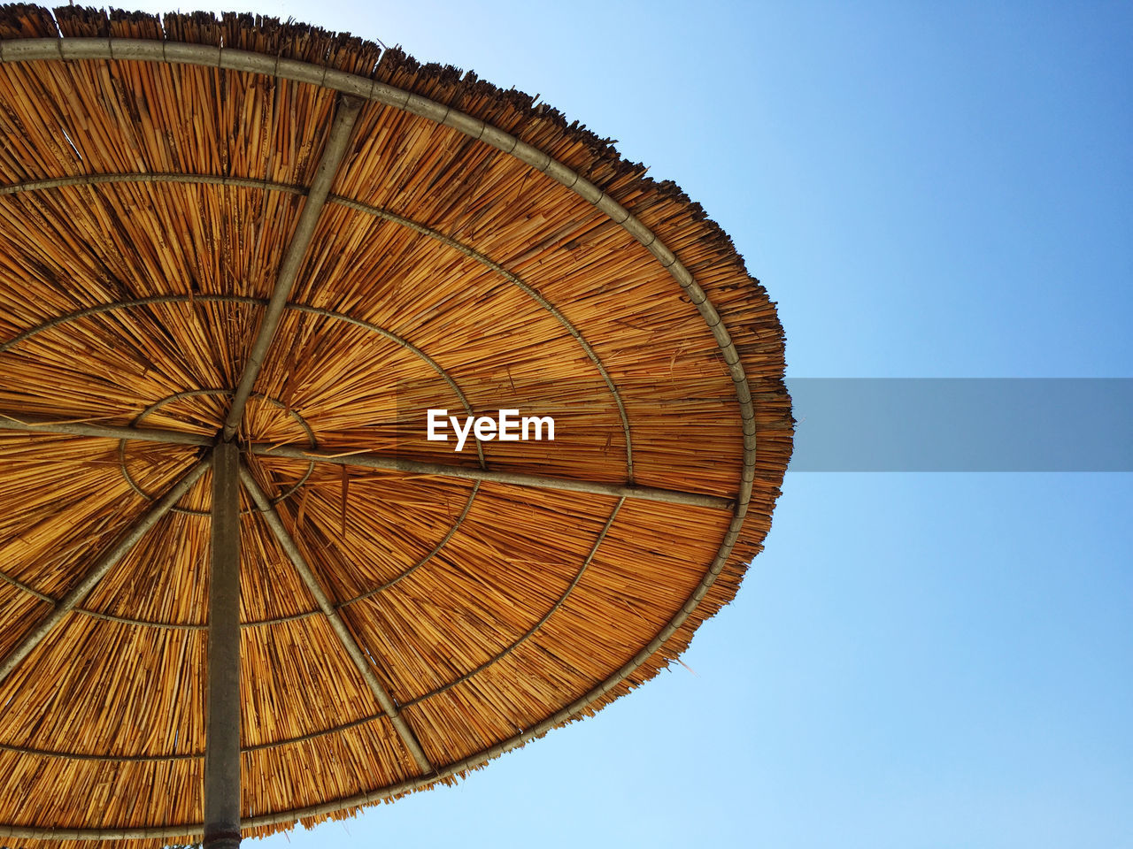 LOW ANGLE VIEW OF THATCHED ROOF AGAINST CLEAR SKY