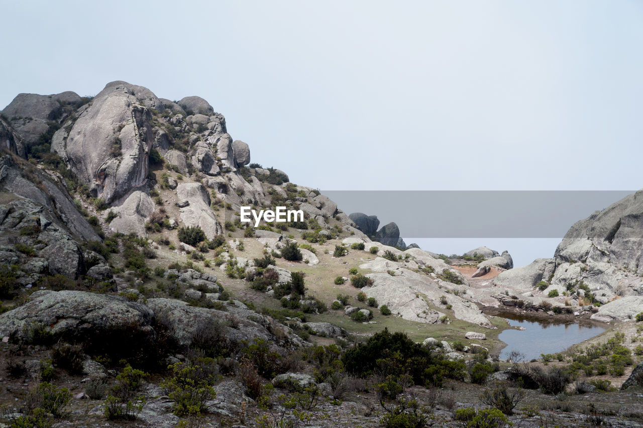 Scenic view of pond amidst rock formation