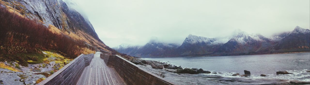 Walkway at seaside against sky