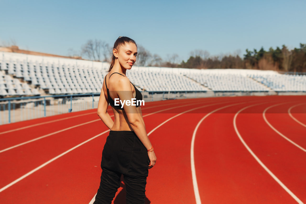 Portrait of female athlete standing on running track