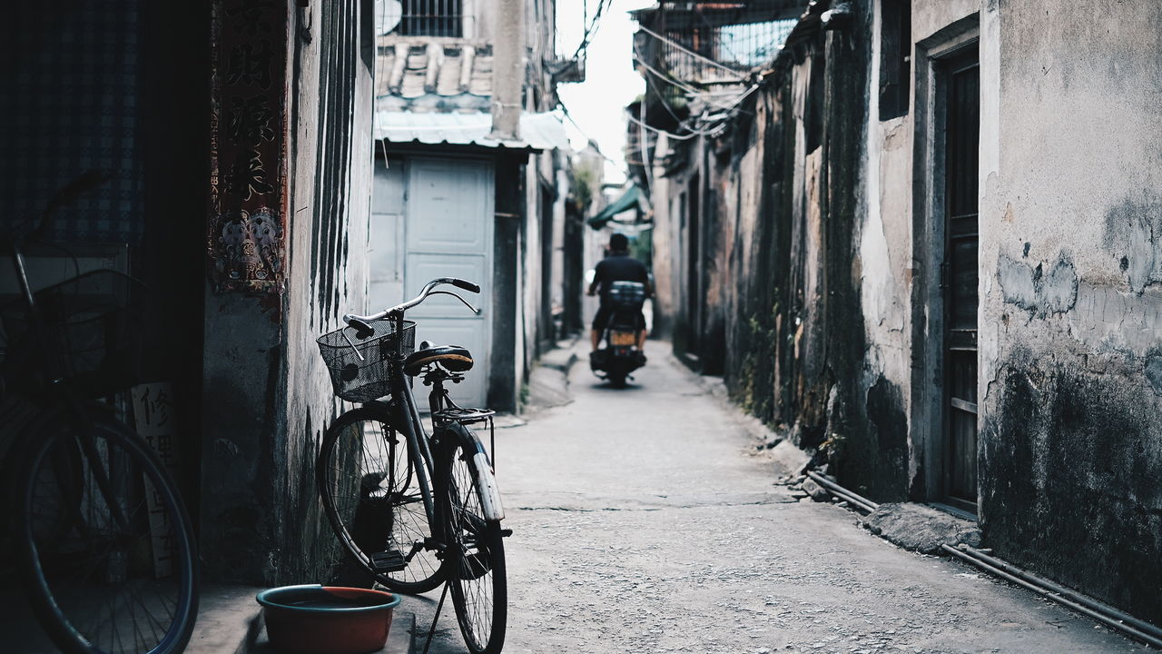 MAN ON BICYCLE BY CITY