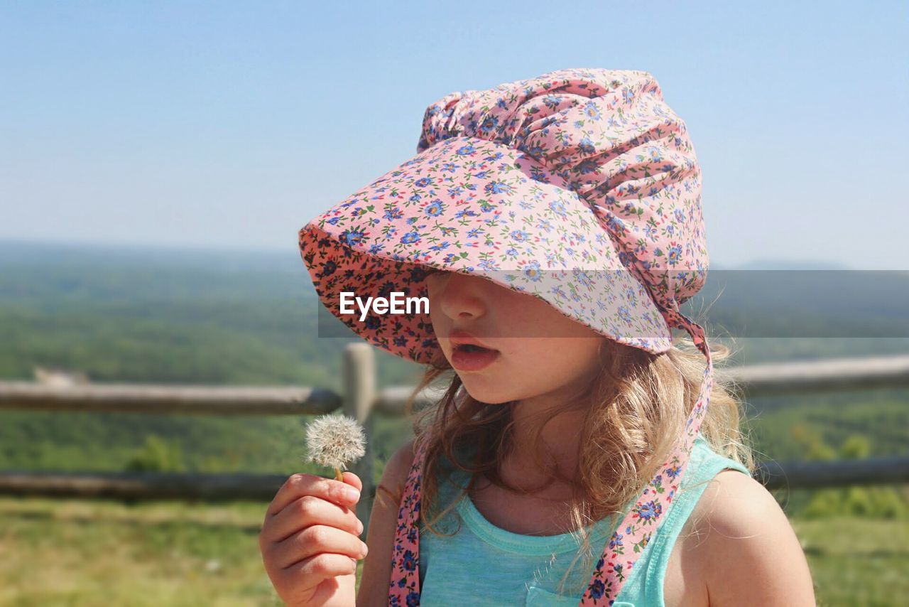 Close-up of girl against clear sky